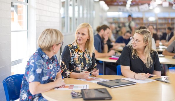Teachers interacting in a staff meeting.