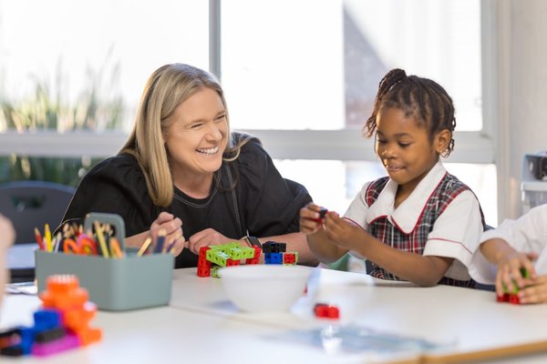 A teacher and a student interacting in a classroom.