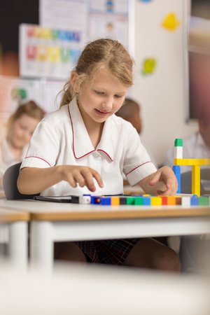 A young student working in a classroom.